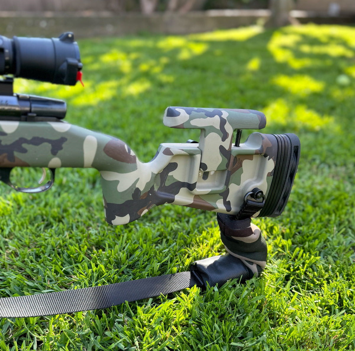 Sling Steady rear squeeze bag in woodland camo on the sling under a camo bolt-action rifle stock